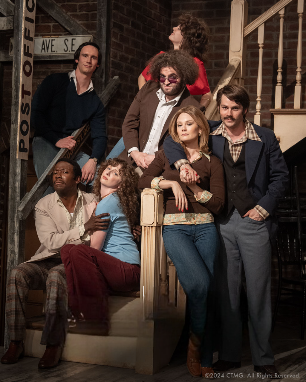 The Cast of Saturday Night recreating the photo of the original SNL cast at the foot of the stairs in a brick building. www.streamingmovienight.com